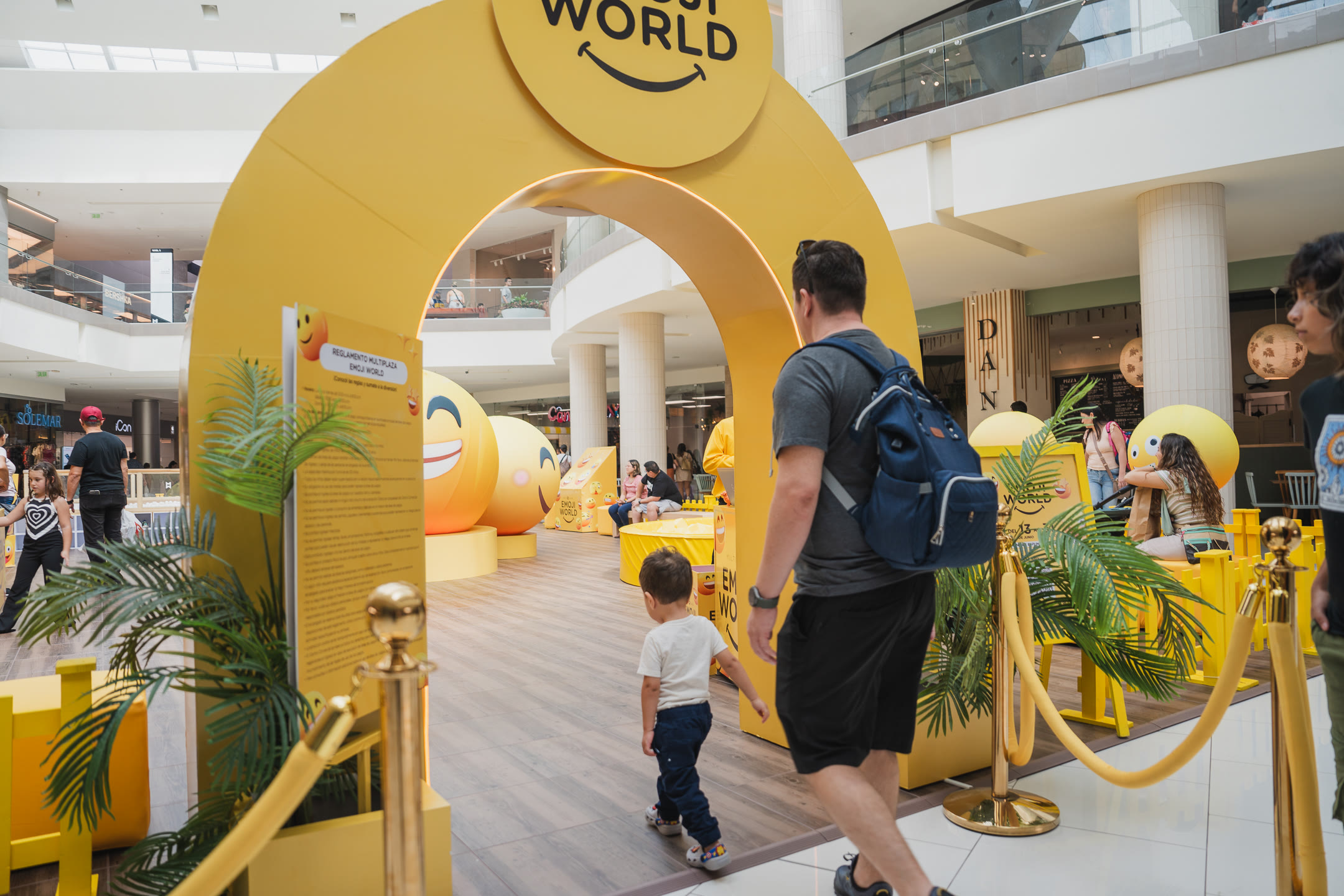 Entrada de la experiencia Emoji World en Multiplaza con arco de bienvenida, decoración temática y visitantes
