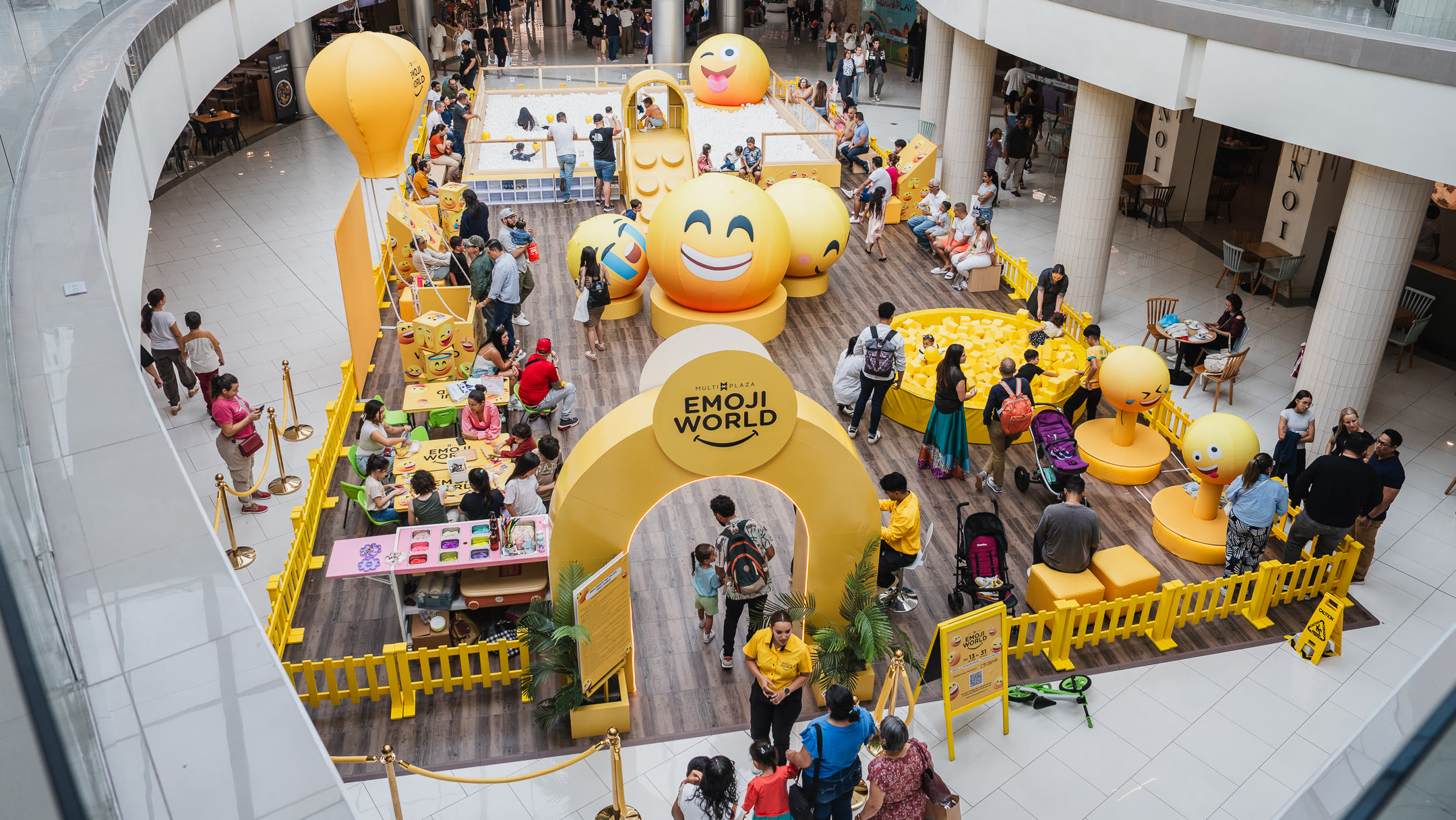 Vista aérea de Emoji World en Multiplaza con zonas de juego, piscina de cubos y familias participando